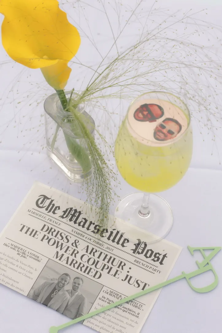 Faux journal « The Marseille Post » annonçant le mariage, cocktail au visage des mariés et fleur d'arum jaune