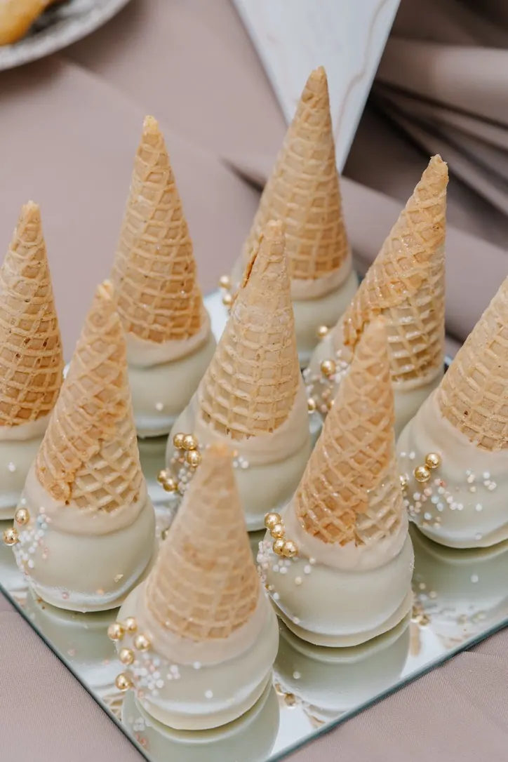 Cônes gaufrés enrobés de chocolat blanc et de perles nacrées sur un miroir