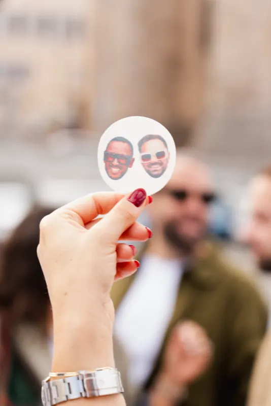 Une invitée tient un sticker personnalisé avec les visages des mariés